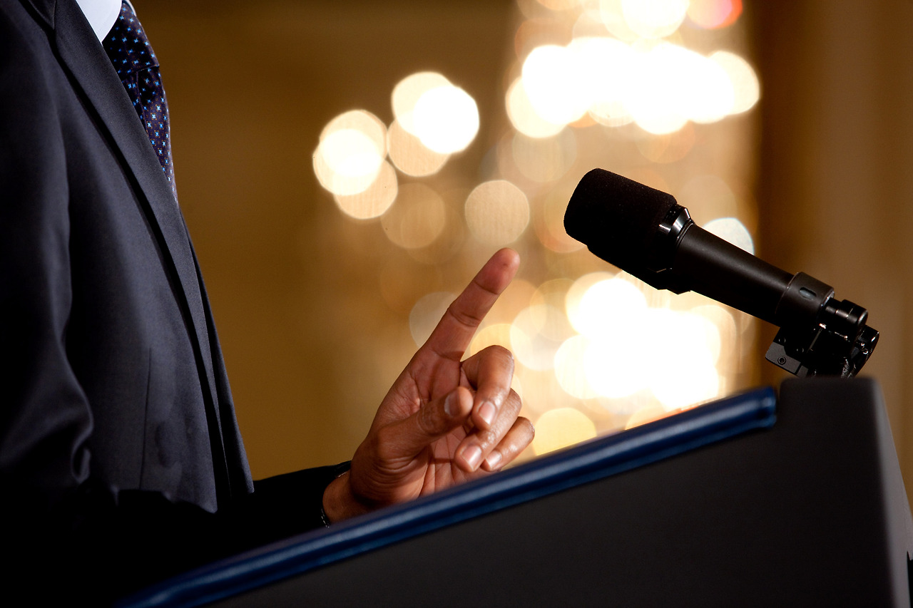 0519-0908-0820-3533_close_up_of_a_man_making_a_point_during_a_speech_microphone_and_podium_in_view_o1.jpg