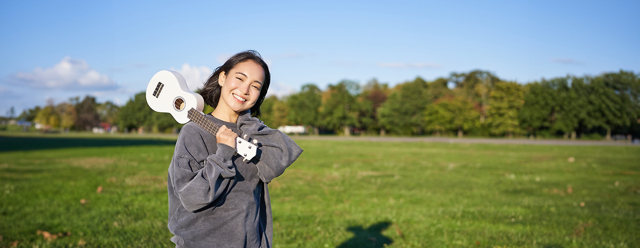 portrait-beautiful-smiling-girl-with-ukulele-asian-woman-with-musical-instrument-posing-outdoors.jpg