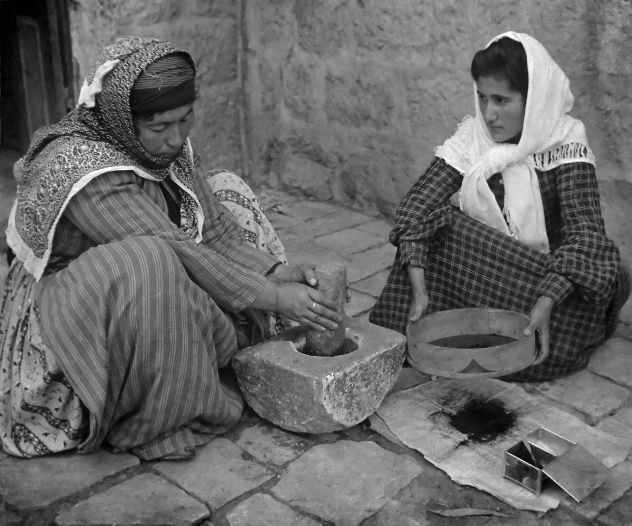 Två kvinnor som mal kaffe på traditionellt vis i Palestina 1905-1905년 팔레스타인~ (1).jpg