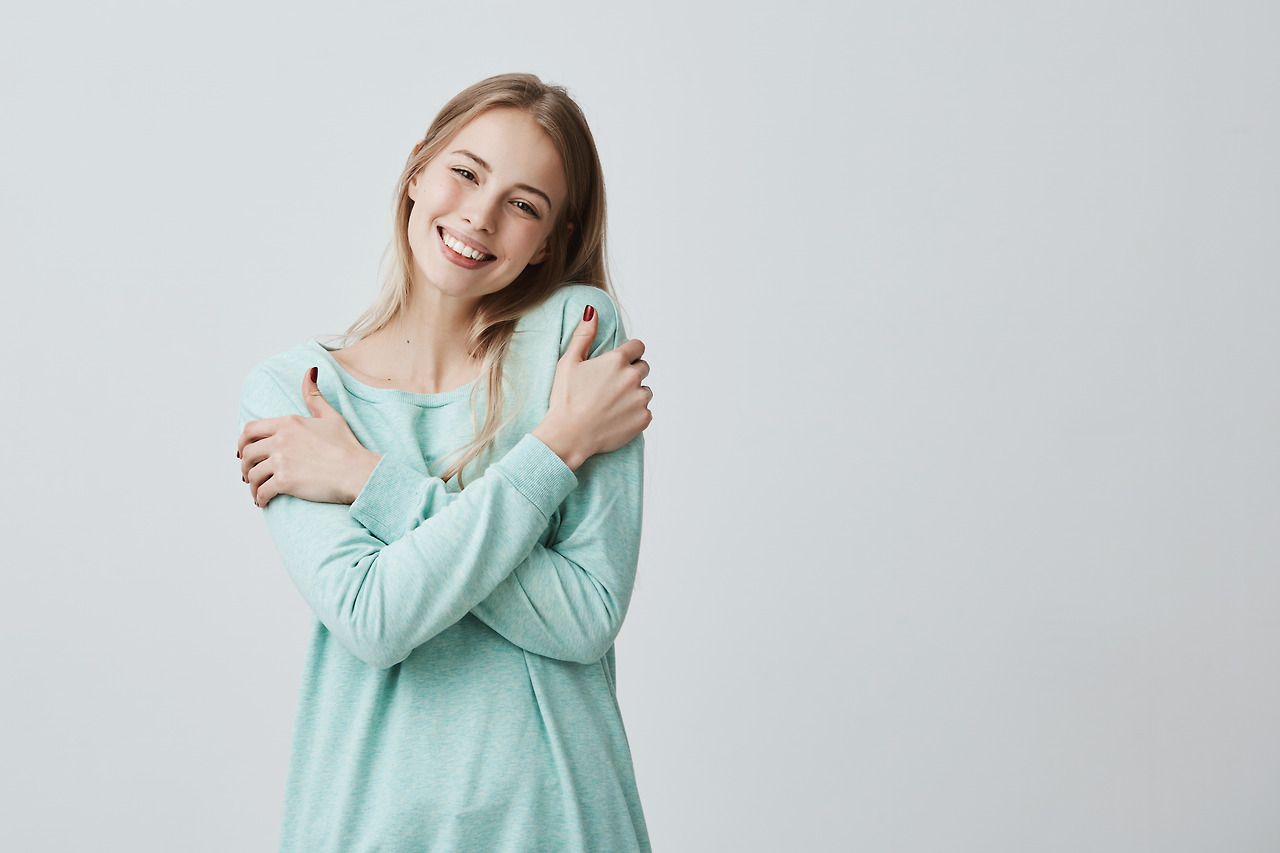 portrait-lovely-positive-young-european-female-with-charming-smile-long-blonde-hair-enjoying-soft-fabric-her-new-light-blue-sweater-posing.jpg