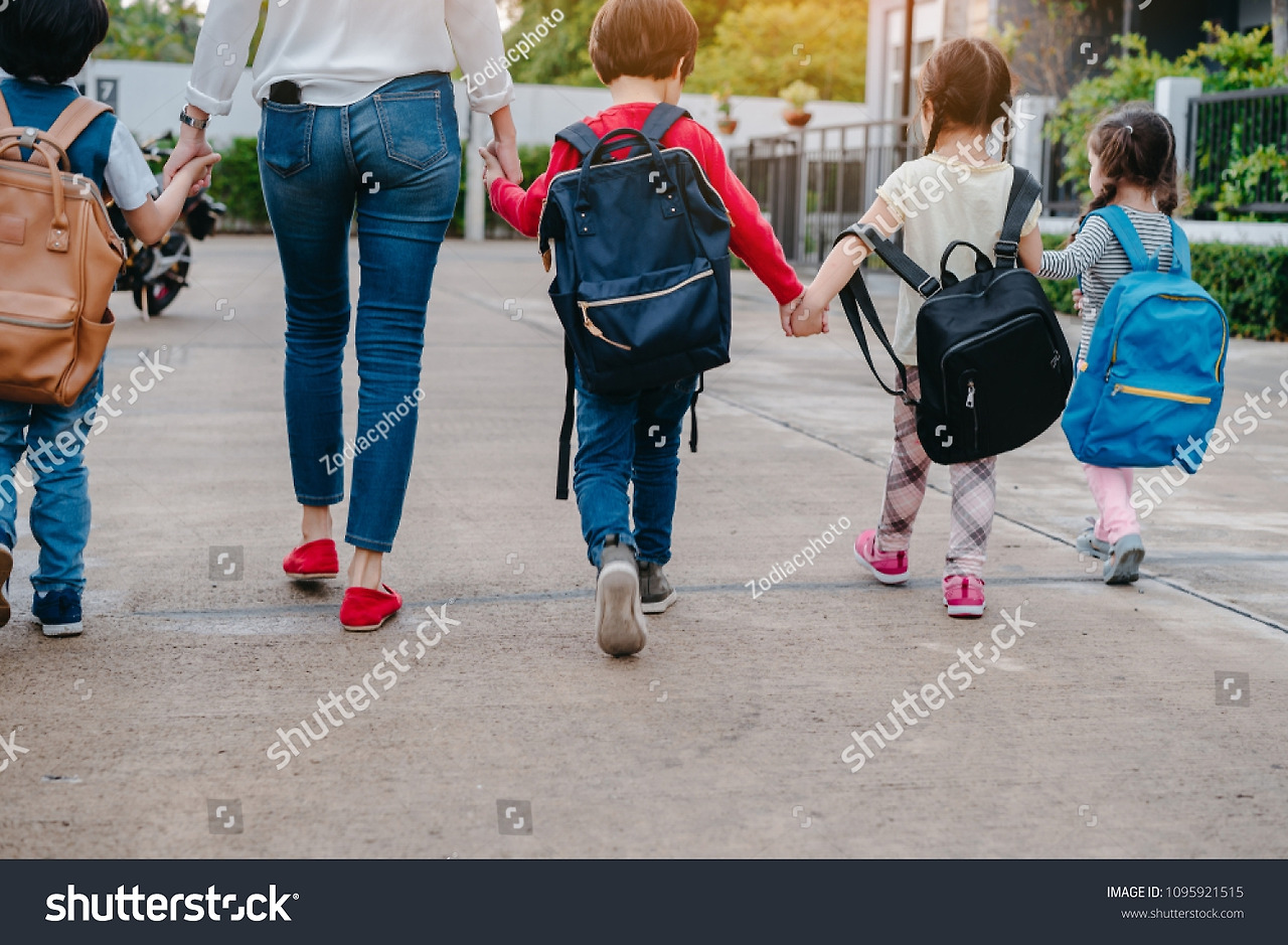 stock-photo-mother-and-pupil-and-kids-holding-hands-going-to-school-in-first-class-with-schoolbag-or-satchel-1095921515.jpg