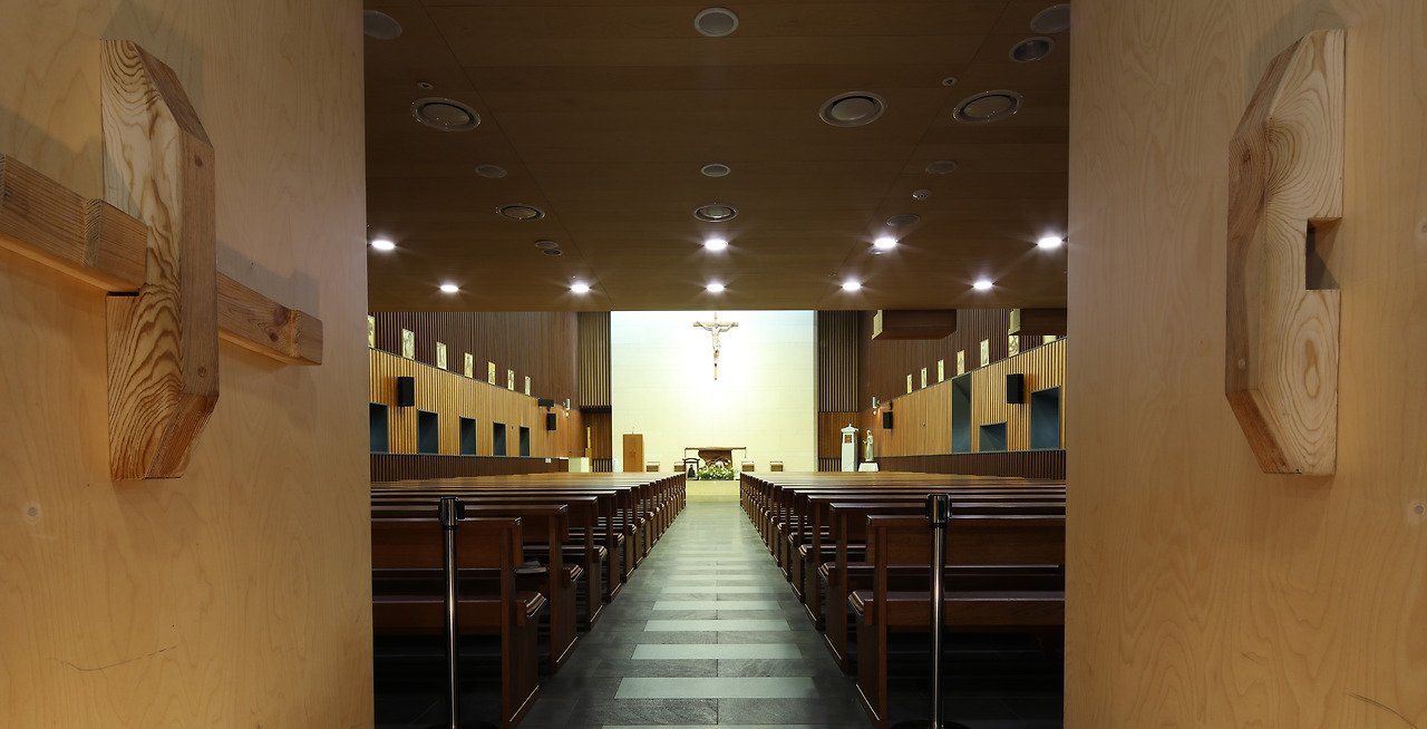 사진5_가회동 성당 성전 내부와 한옥 대문 형태의 성전 출입문. 성전은 전체적으로 목조 구조지만 자연광을 최대한 살리기 위해 환한 석판 위에 십자가 예수상을 설치했고 출입문은 한옥과 조화를 꾀했다. ⓒ포스트픽.jpg