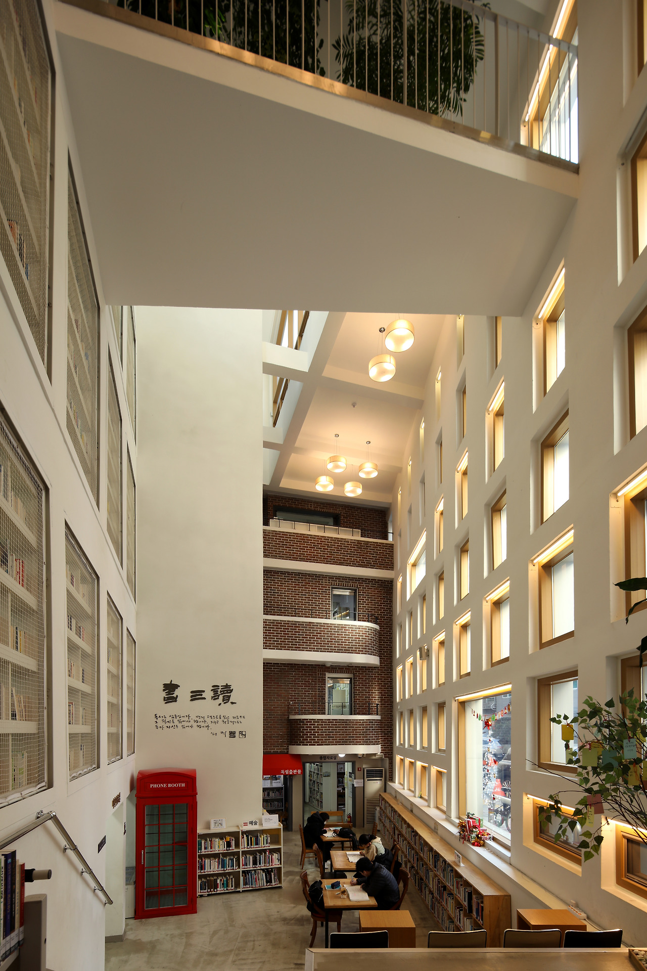 사진3_구산동도서관마을 1층 로비 공간. 과거 주택 앞마당이자 골목이었던 공간이다. 고 신영복 선생의 '서삼독' 글씨가 크게 걸려있다.  ⓒ포스트픽.jpg