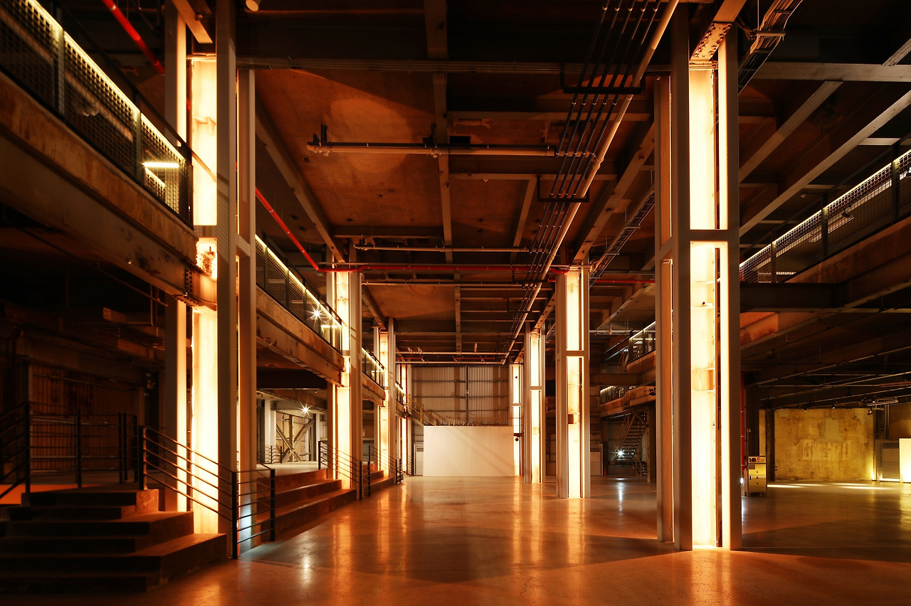 사진5_1, 2층을 하나로 묶은 전시공연장. 기다랗게 빛을 뿐는 곳이 기둥이다. 옛 공장의 철골기둥을 4개의 각기둥이 둘러싸고 있다.  각기둥이 새로 관입된 철골유리구조물의 기둥이다. ⓒ포스트픽.jpg