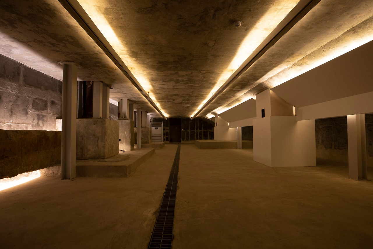 사진10-옛 공장 건축과 새 철골유리 건축의 뿌리가 하나임을 보여주는 지하1층 벙커의 기초구조물. 공장기둥인 철골 기둥을 새 건축의 기둥인 4개의 각기둥이 감싸고 있다. ⓒ권재현.jpg