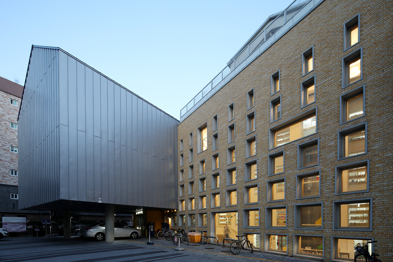 사진2_메인_구산동도서관마을 외경. 골목길 공간을 도서관 안으로 흡수하기 위해 설치한 노란색 벽면의 유리창은 위에서 아래로 갈수록 넓어어진다. 건물 아래일수록 채광이 불리한 단점을 보완하는 한편 내부를 들여다보고 친근감을 느끼도록 하기 위해서다. ⓒ포스트픽.jpg