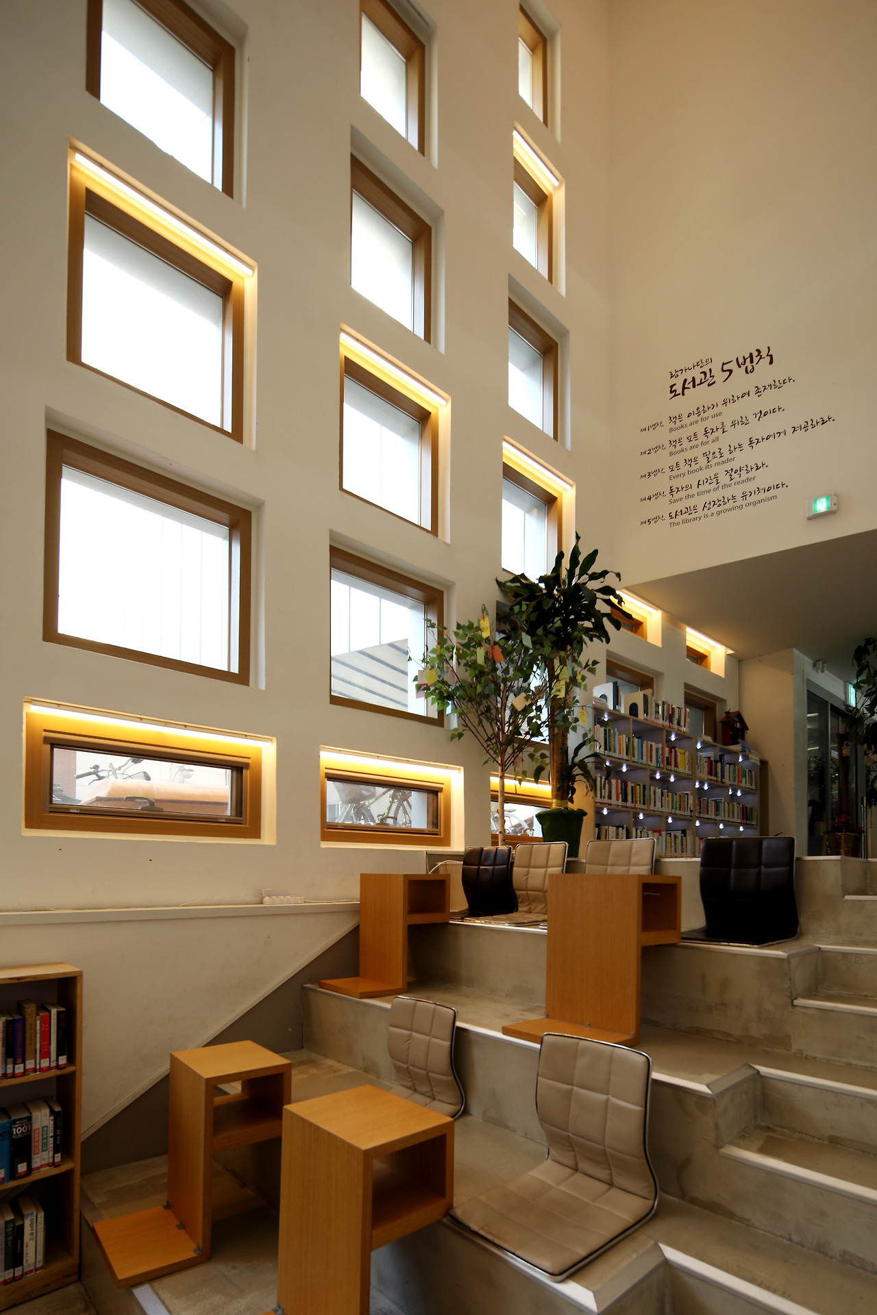 예비-도서관마을 노란 벽면의 안쪽에 해당하는 로비공간. 아래로 갈수록 커지는 창문을 확인할 수 있다. ⓒ포스트픽.jpg