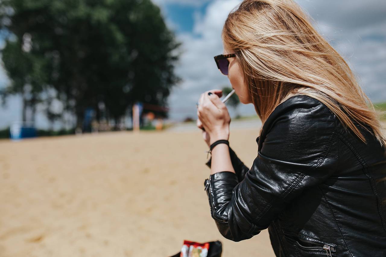 Copy ofkaboompics_Young woman smoking on the beach.jpg