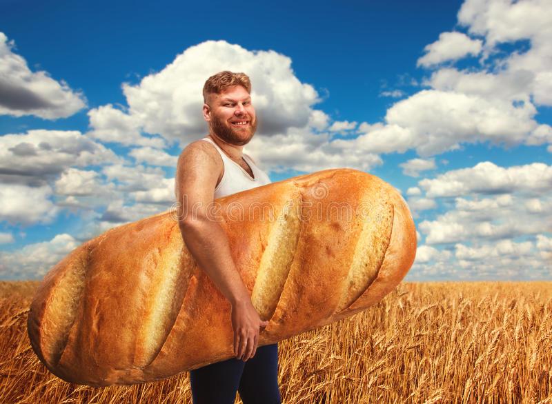 man-holding-huge-bread-field-wheat-smiles-51405792.jpg