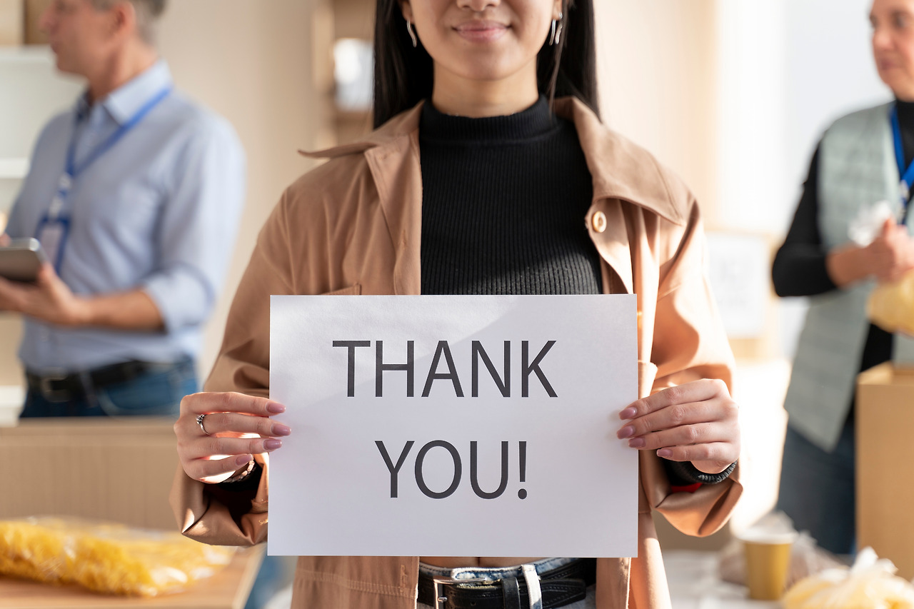 close-up-woman-holding-thank-you-sign.jpg