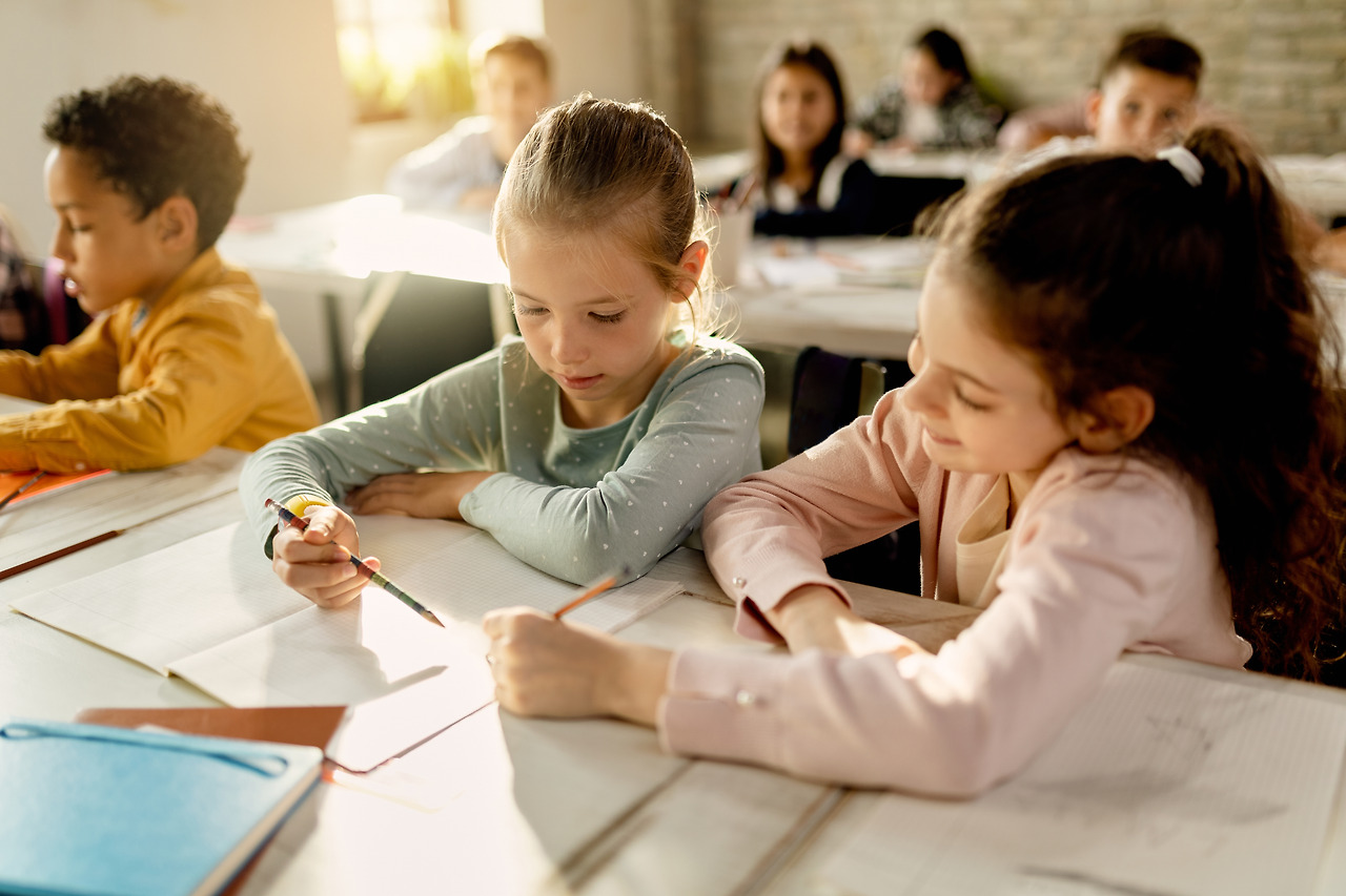 two-schoolgirls-working-together-assignment-classroom.jpg