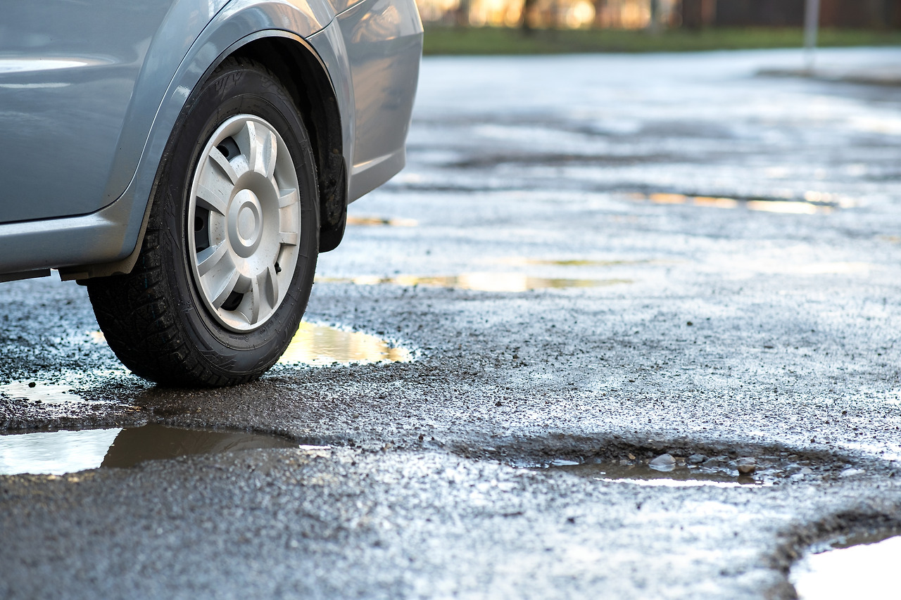 close-up-of-car-wheel-on-a-road-in-very-bad-condit-2022-01-05-19-06-38-utc.jpg