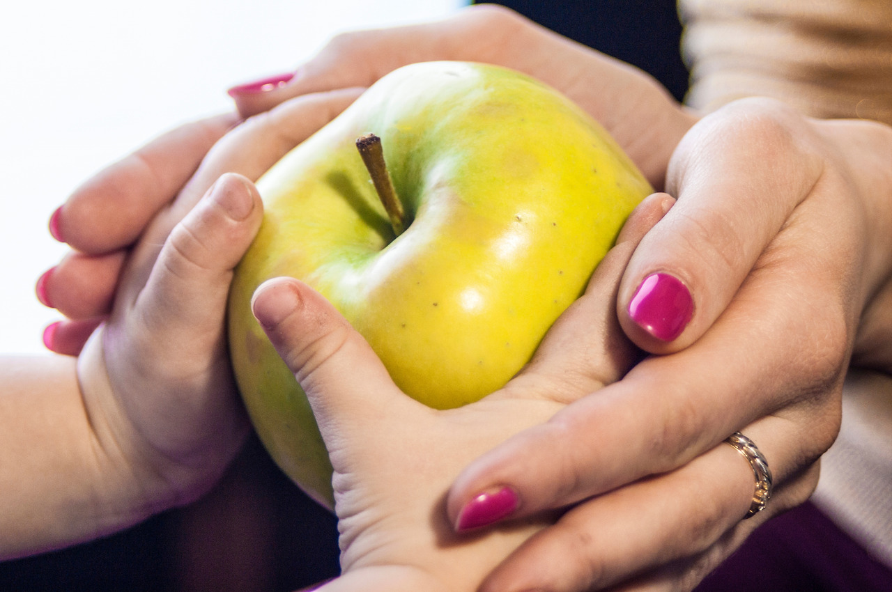 mom-gives-the-child-an-apple-in-her-hands-2023-11-27-05-24-15-utc.jpg
