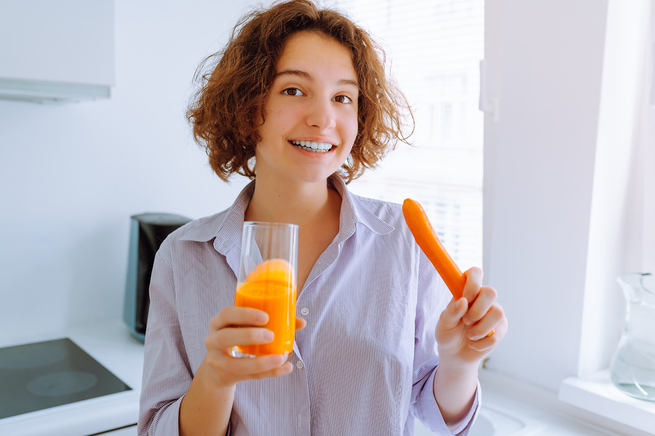 young-woman-drinks-vitamin-carrot-juice-in-morning-2022-11-16-17-11-52-utc.jpg