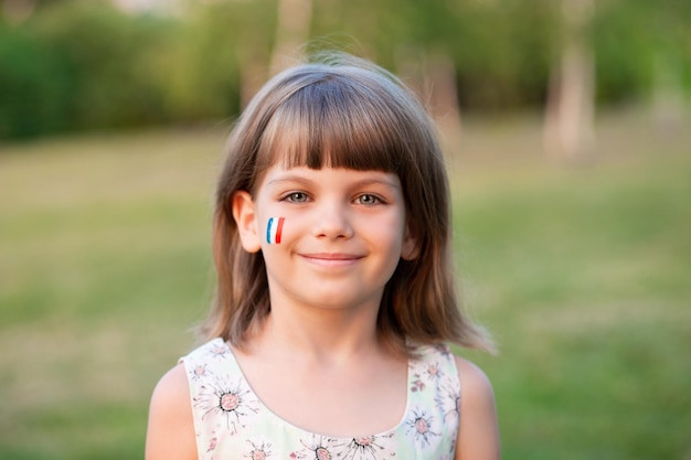 outdoor-portrait-of-little-caucasian-kid-girl-with-cheeks-painted-in-france-flag-colors-and-looking-into-camera-and-smile-young-painter_438419-169.jpg