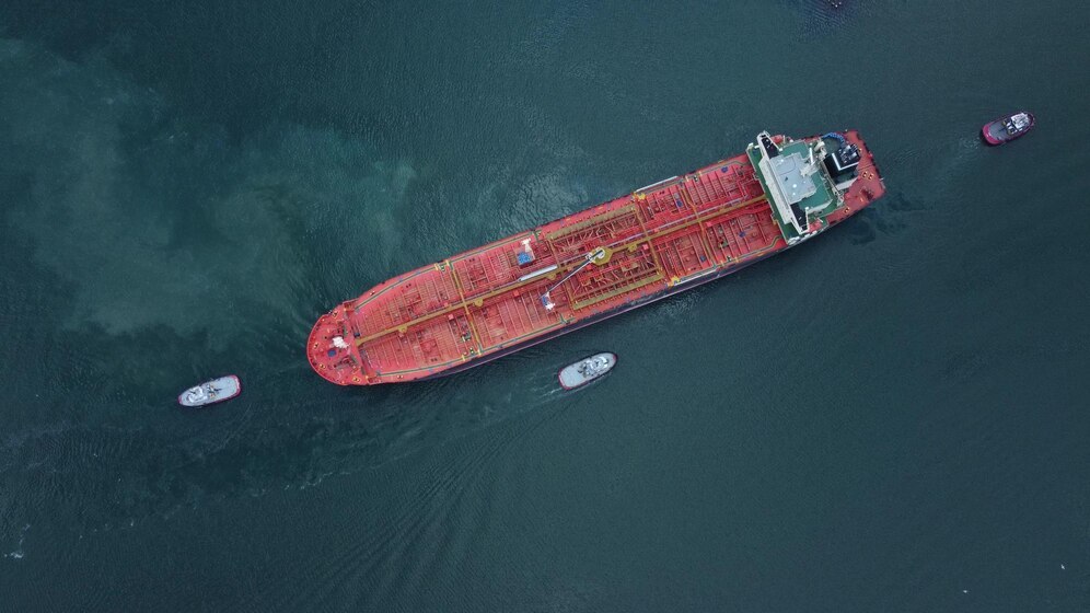 aerial-view-tanker-ship-with-escorting-tug-leaving-port_213438-5445.jpg