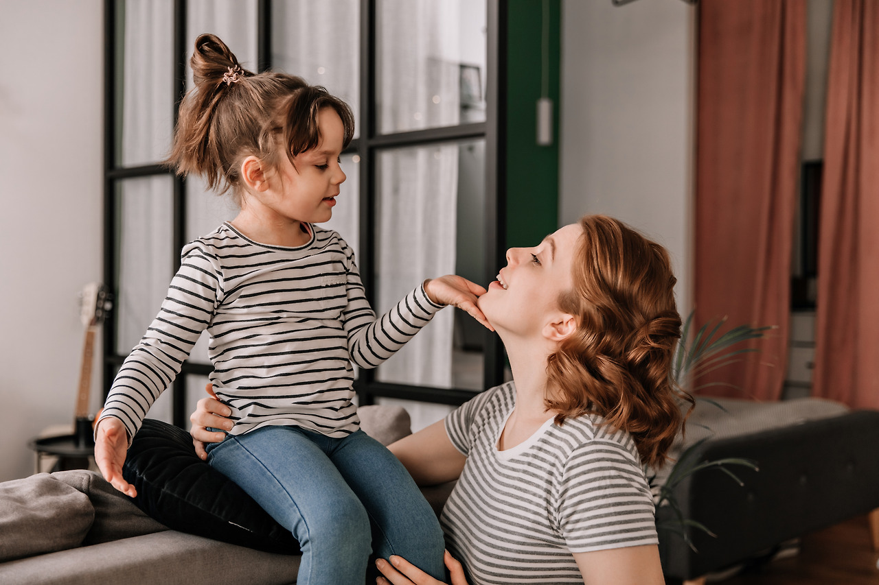 child-striped-t-shirt-is-sitting-sofa-stroking-his-mothers-face.jpg