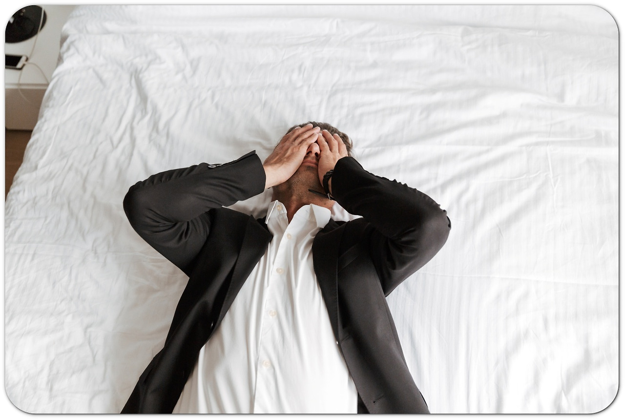퇴근-후-침대에-누운-피곤한-정장-입은-남성.jpg