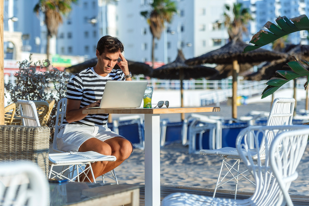 man-with-laptop-sitting-on-the-terrace-of-a-beach-2022-12-16-22-46-04-utc.jpg