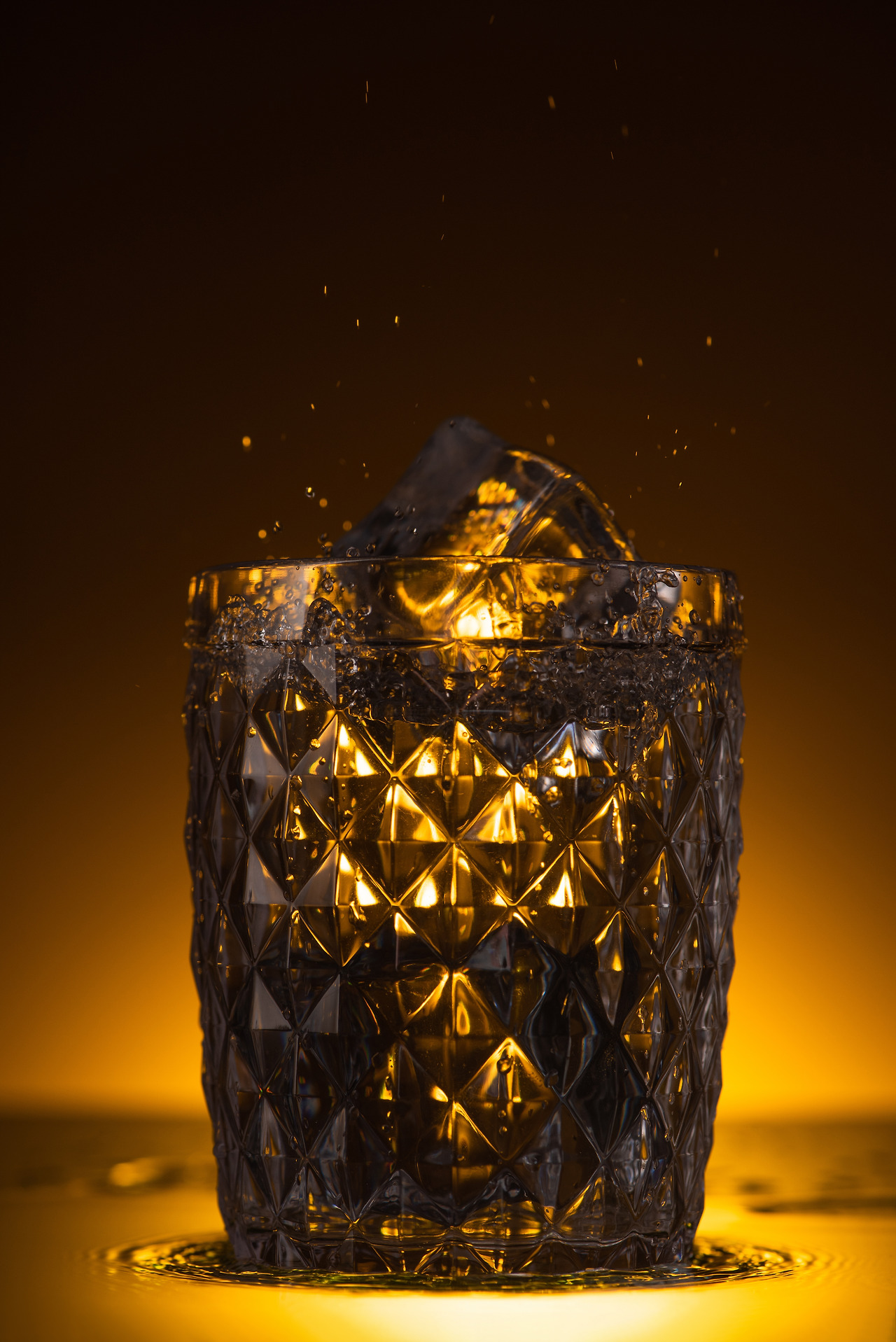 faceted-glass-with-ice-cube-and-splashing-vodka-in-2023-11-27-05-31-47-utc.jpg