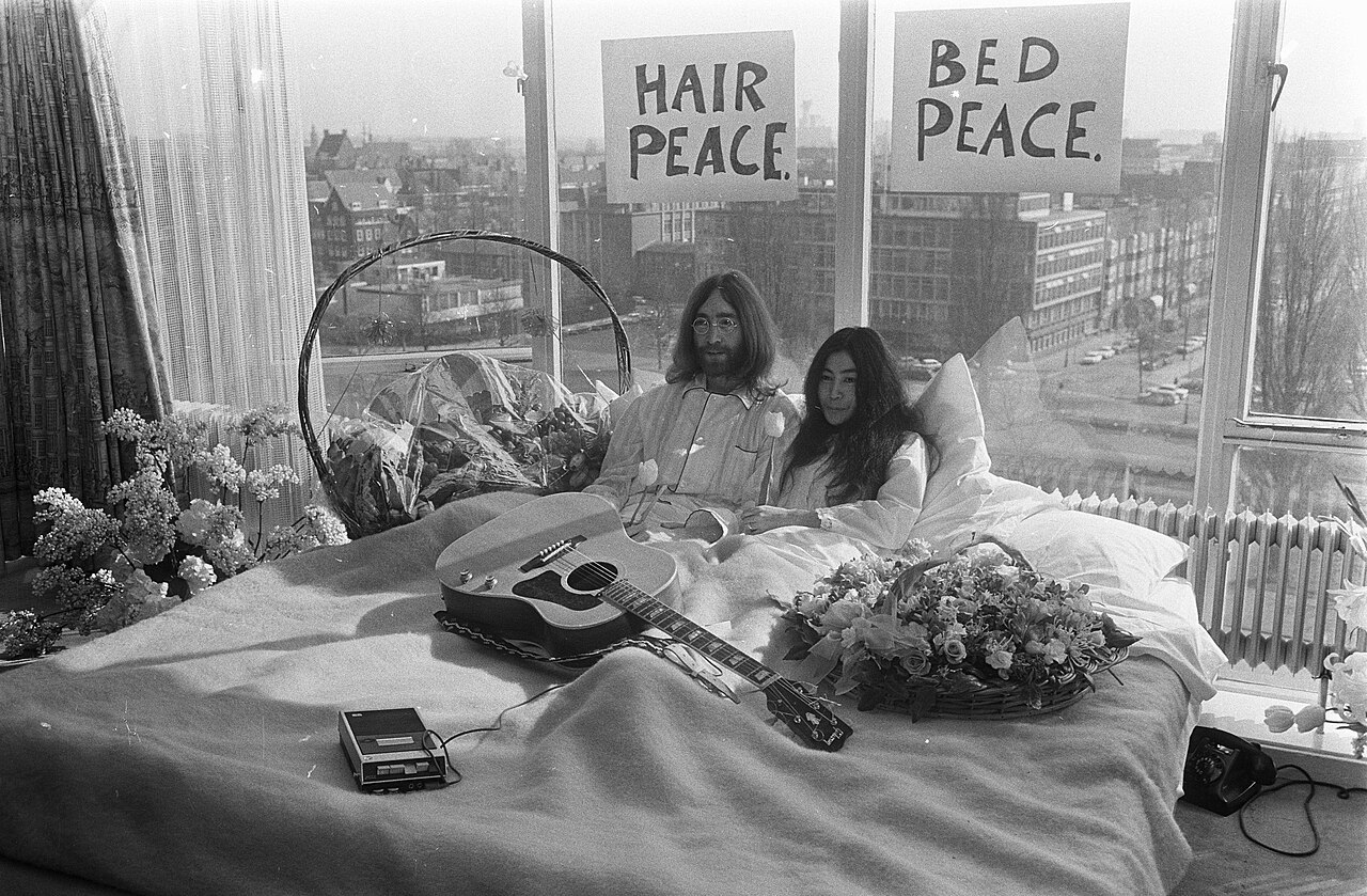 John_Lennon_en_zijn_echtgenote_Yoko_Ono_op_huwelijksreis_in_Amsterdam._John_Lenn,_Bestanddeelnr_922-2302.jpg
