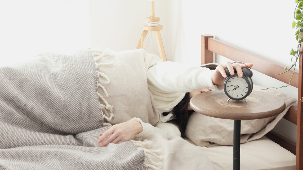a-woman-who-turns-off-her-alarm-clock-in-the-morni-2025-03-15-07-04-11-utc.jpg