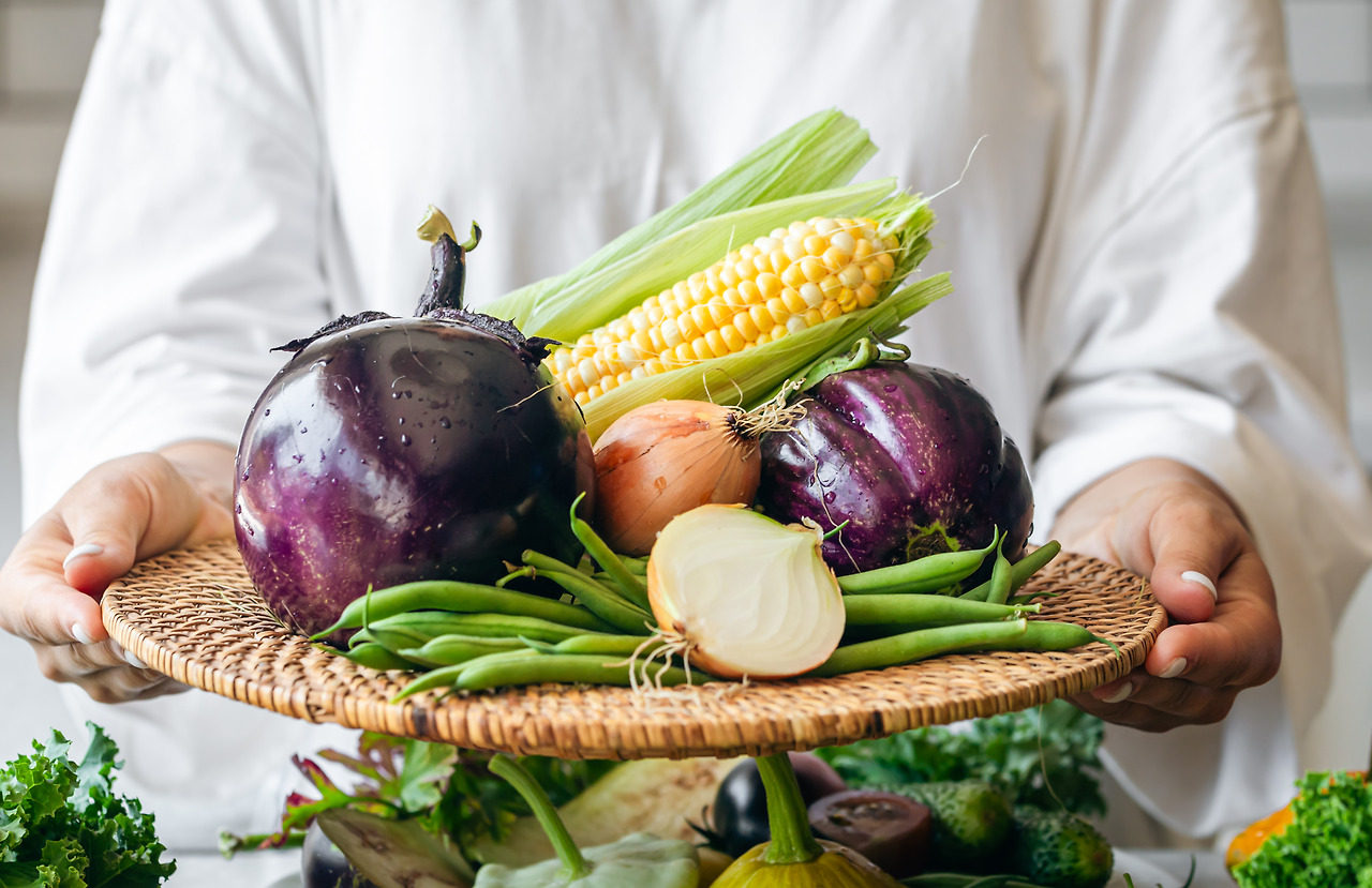 a-woman-holds-a-plate-with-eggplant-onion-corn-a-2025-03-15-01-33-25-utc.jpg