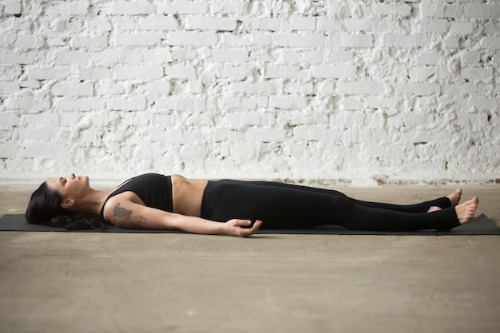 young-yogi-attractive-woman-savasana-pose-white-loft-backgro_1163-3106.jpg