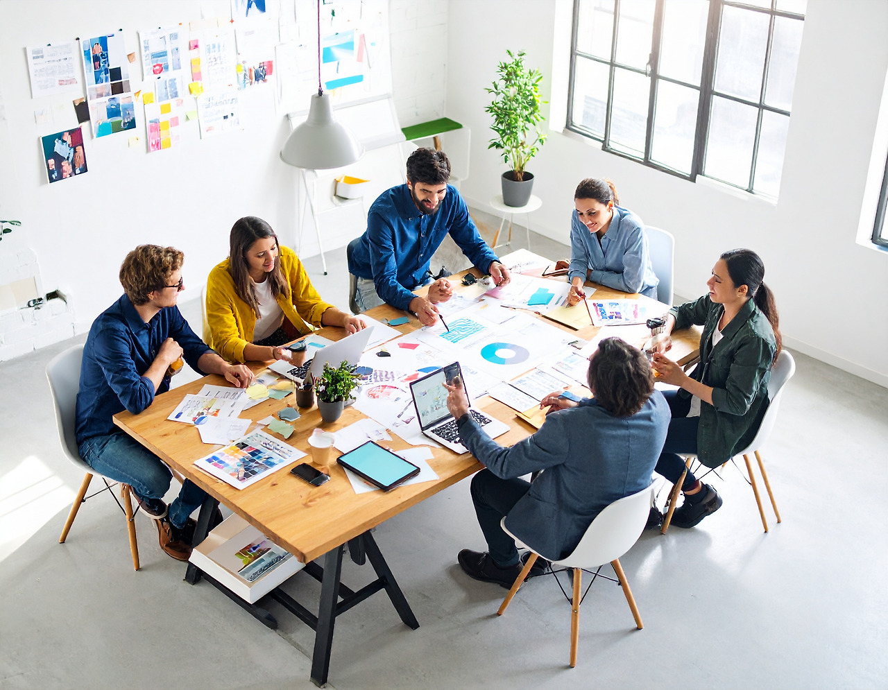 Firefly_A group of young creative professionals collaborating on a design project, gathered a 719483.jpg