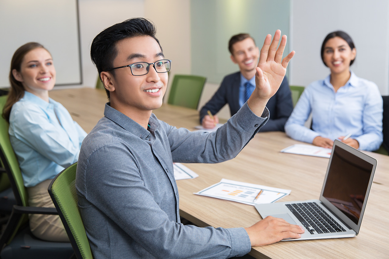 smiling-businessman-raising-hand-at-conference.jpg