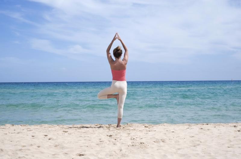 woman-doing-yoga-on-the-beach-453617873.jpg