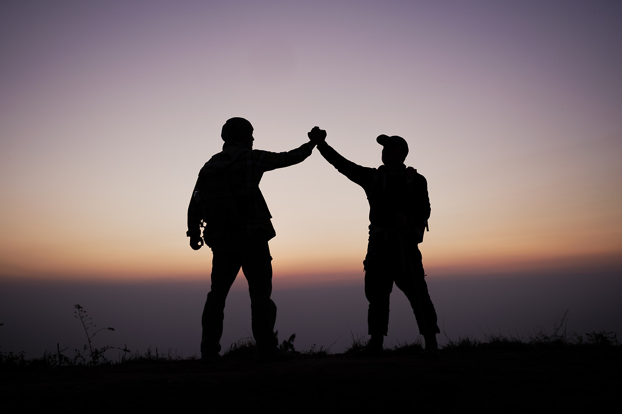 silhouette-teamwork-helping-hand-trust-help-success-mountains-hikers-celebrate-with-hands-up-help-each-other-top-mountain-sunset-landscape.jpg