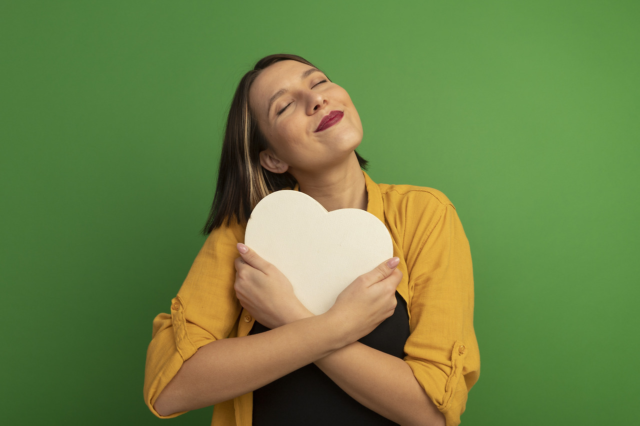pleased-pretty-caucasian-woman-hugs-heart-shape-green.jpg