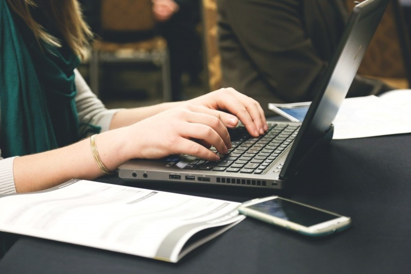 woman-working-on-laptop-with-mobile-phone-on-table.jpg