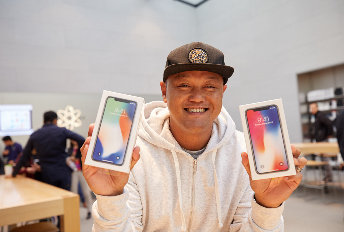 iPhone_X_Launch_PaloAlto_man_holding_two_phones_20171102.jpg