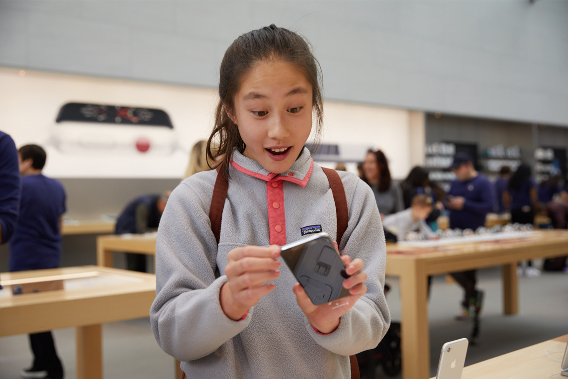 iPhone_X_Launch_PaloAlto_woman_in_fleece_holding_product_20171102.jpg