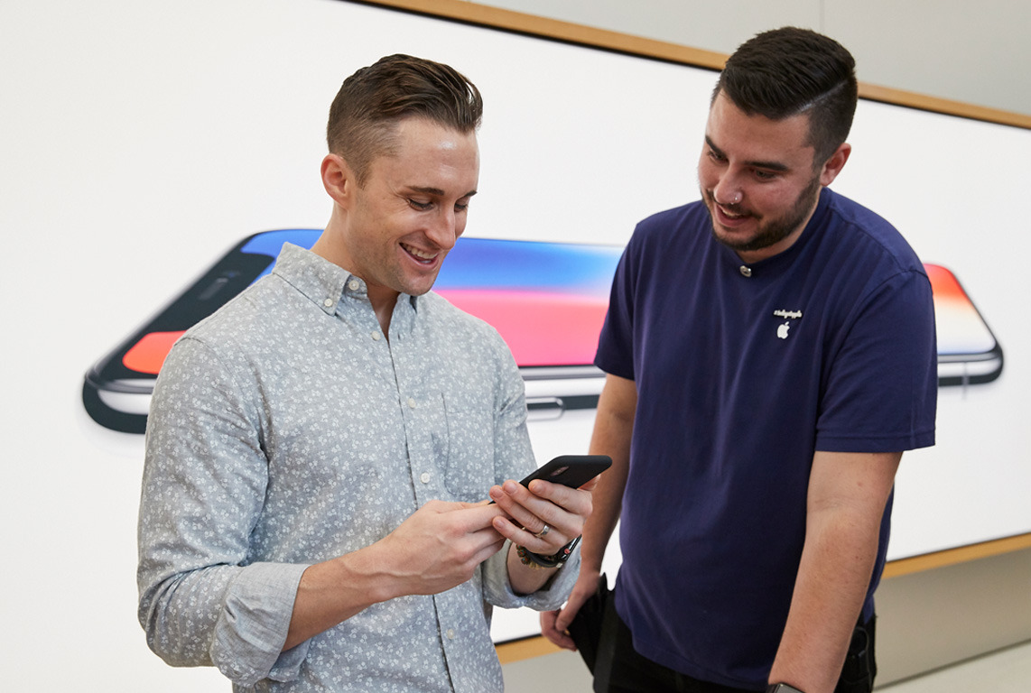 iPhone_X_Launch_UnionSquare_SanFrancisco_man_using_phone_with_employee_20171102.jpg