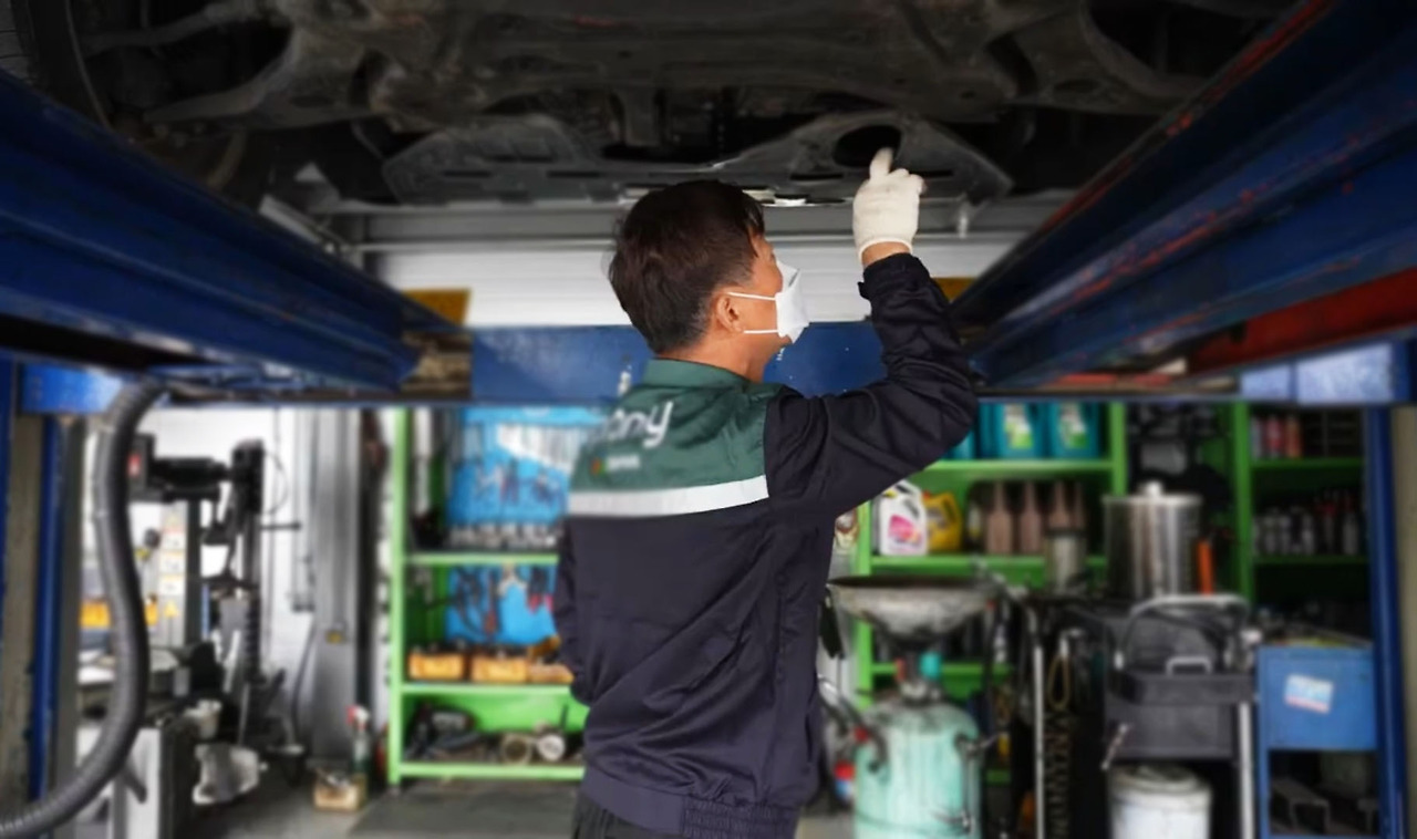 작업대 위에 올려놓은 자동차를 수리하고 있는 김태현 사장.jpg