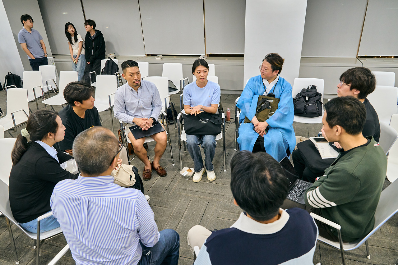 About a dozen attendees seated in a circle of white chairs for the closing small-group discussion.