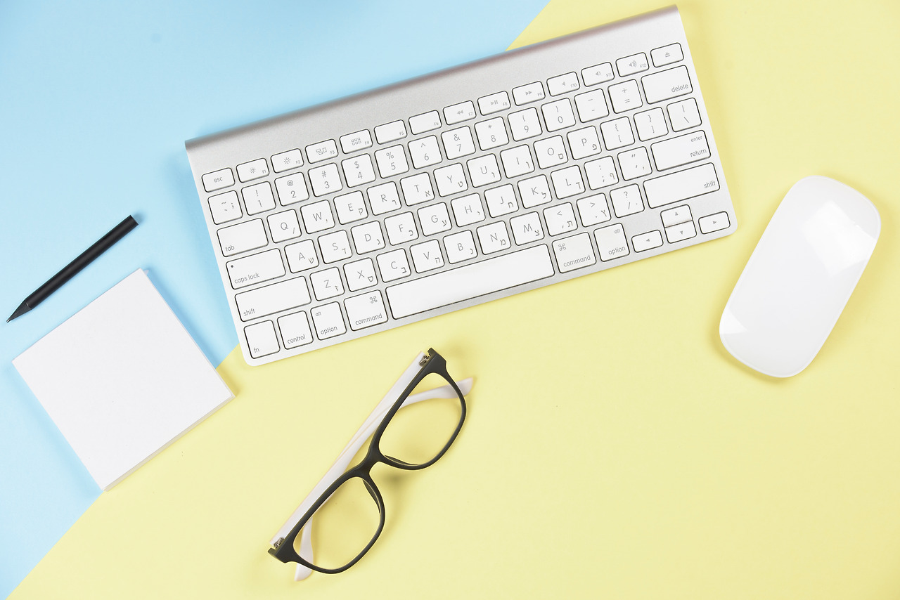 pencil-adhesive-notepad-eyeglasses-wireless-keyboard-mouse-blue-yellow-backdrop.jpg