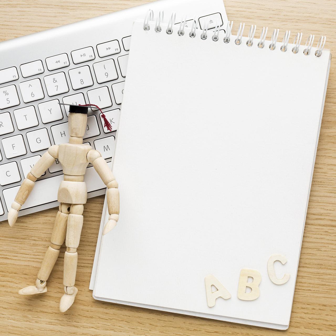 top-view-wooden-figurine-with-academic-cap-notebook.jpg
