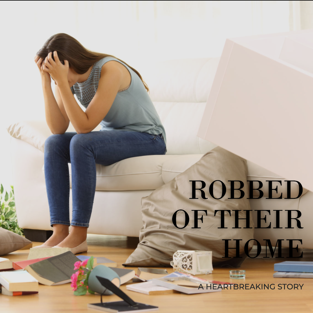 A young couple crying under an umbrella in the street in front of their house on a rainy day after being robbed of their home by fraud..png