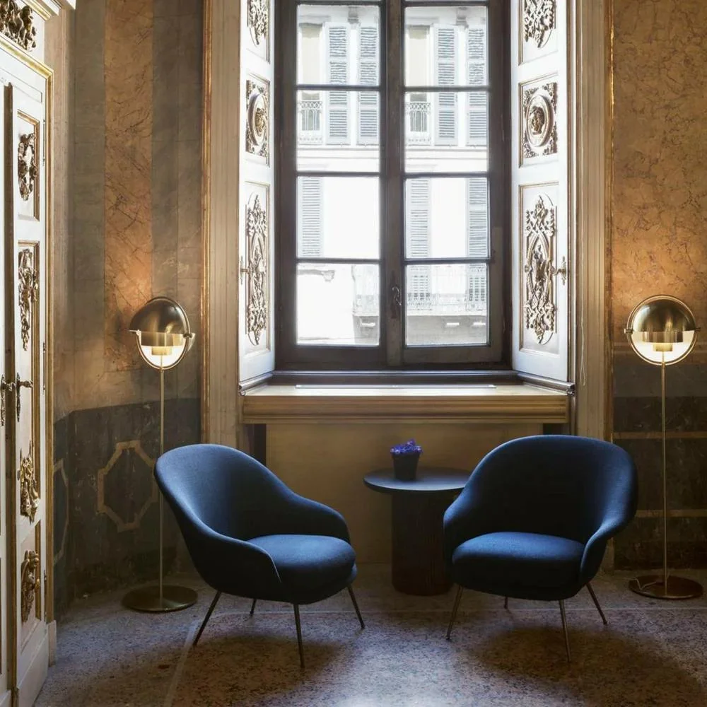 gubi-multi-lite-floor-lamps-brass-in-room-with-bat-chairs.jpeg