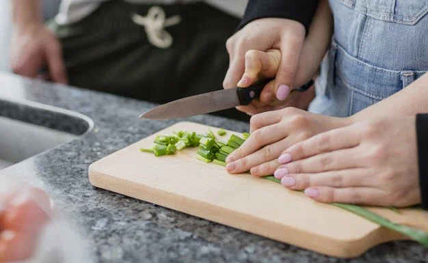 close-up-parents-helping-girl-cut-vegetables_23-2147800414.jpg?type=w1200