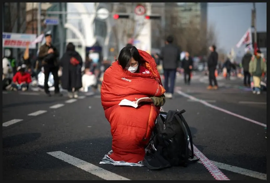 04 04 2025 Seoul, South Korea A woman who stayed the night on the street reads a book while waiting for the constitutional court ruling on President Yoon Suk Yeol’s impeachment in Seoul 진정한 자유의 여신상.JPG