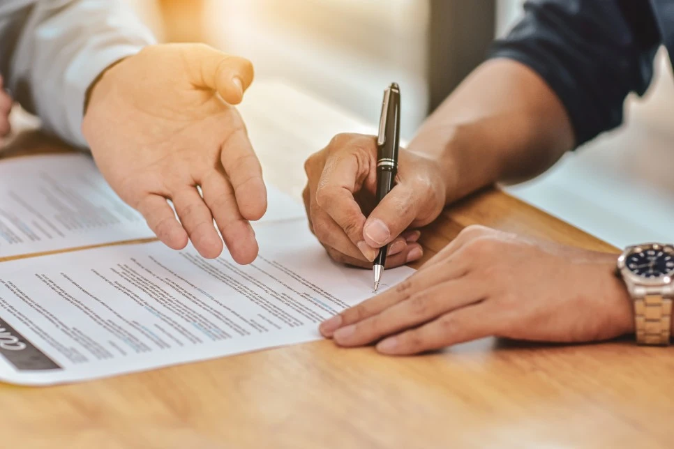 close-up-hand-holding-pen-sign-contract-on-document.jpg?type=w966