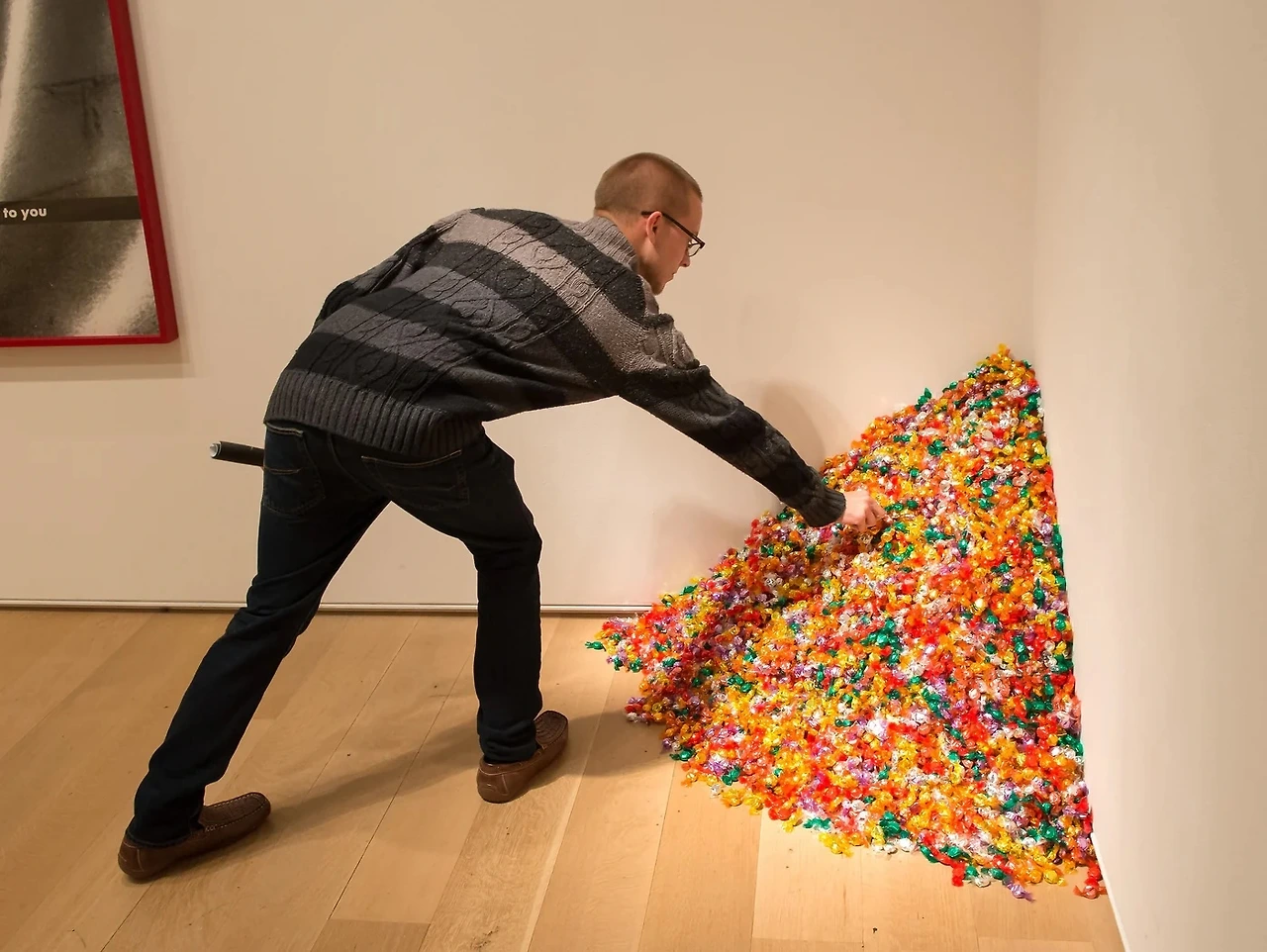 a-man-taking-a-piece-of-candy-from-the-art-piece-2013-mark6mauno-1689372888900_1400x.jpeg