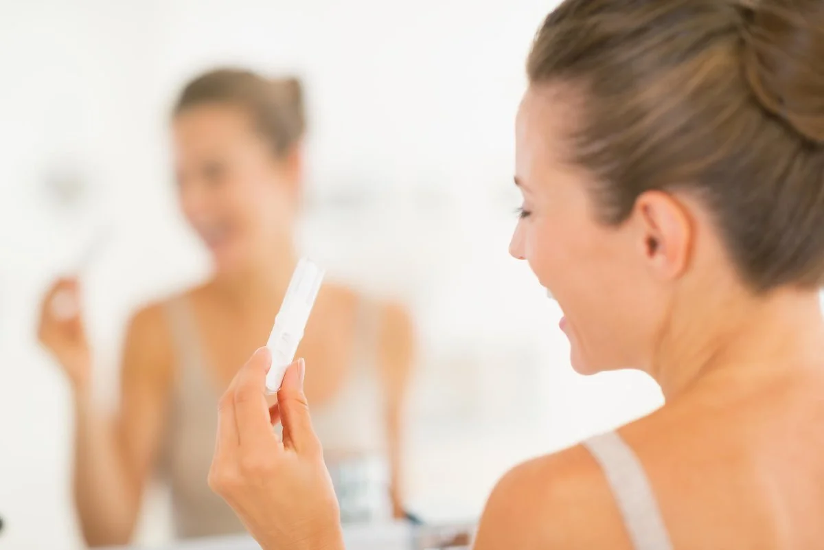 happy-woman-looking-at-pregnancy-test_0.jpg?type=w1200