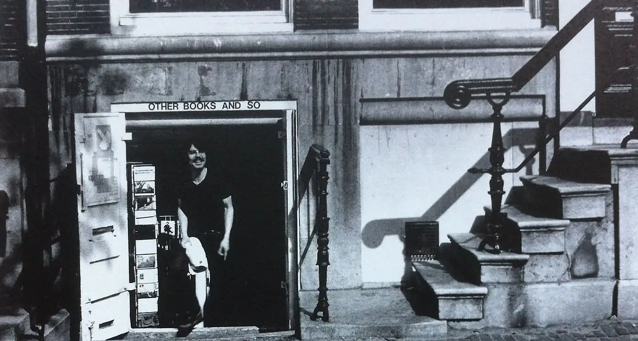 Ulises_Carrion_in_the_door_of_Other_Books_and_So_(Amsterdam_Herengracht_272)_June_1976_photo_by_Guy_Schraenen.jpeg