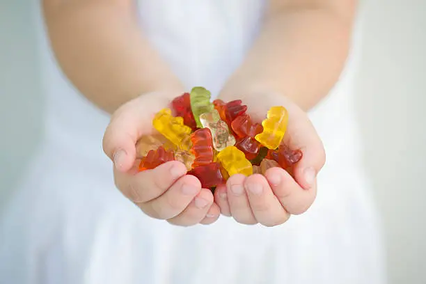 a-little-girl-with-a-handful-of-gummy-bears.jpg?s=612x612&w=0&k=20&c=gotcU2cZPVkTew3Z5NRt2hZW8TqAfGF1cpLYGNKqzko=